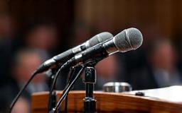 Close-up of microphones at a press conference podium
